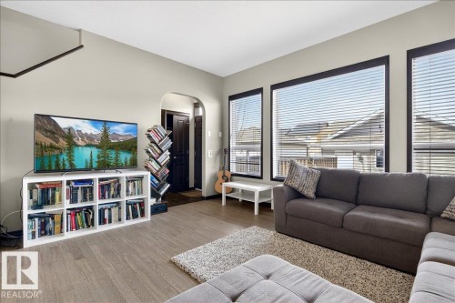 The living area features light-colored walls and flooring, complemented by large windows - 1530 Chapman Way, Edmonton, AB - Indoor Photo Showing Living Room