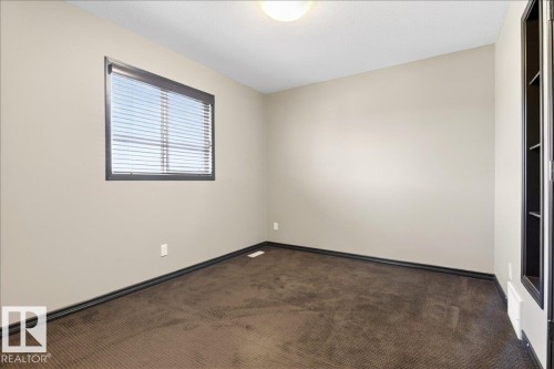 This room features a window with horizontal blinds, carpeted flooring, and light-colored walls - 1530 Chapman Way, Edmonton, AB - Indoor Photo Showing Other Room