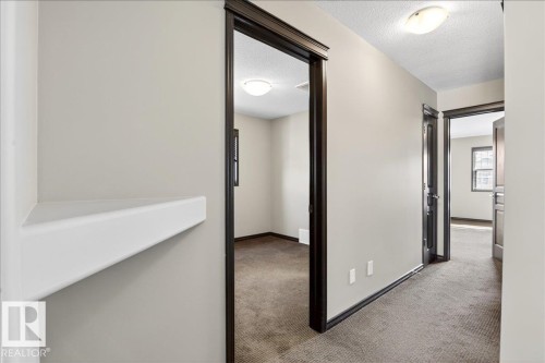 Interior hallway featuring light-colored walls, dark trim, and carpeted flooring - 1530 Chapman Way, Edmonton, AB - Indoor Photo Showing Other Room