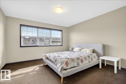 This room features a neutral color palette, a large window with blinds, and carpeted flooring - 1530 Chapman Way, Edmonton, AB - Indoor Photo Showing Bedroom