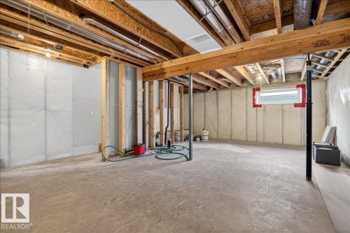The property features an unfinished basement with exposed wooden beams and structural supports, a concrete floor, and a visible window opening - 1530 Chapman Way, Edmonton, AB - Indoor Photo Showing Basement