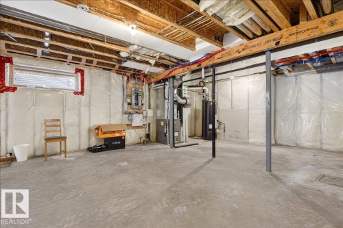 Spacious basement with concrete flooring and exposed ceiling joists - 1530 Chapman Way, Edmonton, AB - Indoor Photo Showing Basement