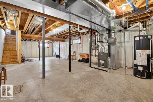 The property includes an unfinished basement featuring exposed ceiling joists, concrete flooring, and a visible water heater and furnace - 1530 Chapman Way, Edmonton, AB - Indoor Photo Showing Basement