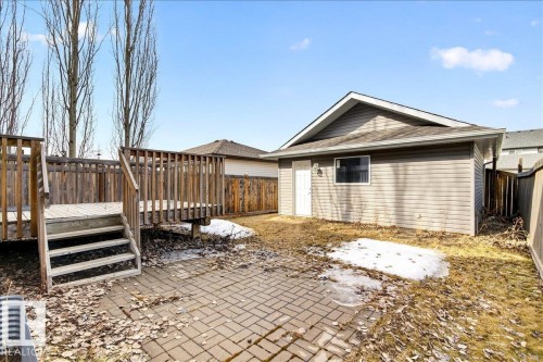 The property features a wooden deck with stairs, a paved patio area, and a detached building with siding - 1530 Chapman Way, Edmonton, AB - Outdoor