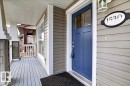The property features a welcoming front porch with wood flooring, siding, and a vibrant blue front door with a window - 1530 Chapman Way, Edmonton, AB  - Outdoor With Exterior 