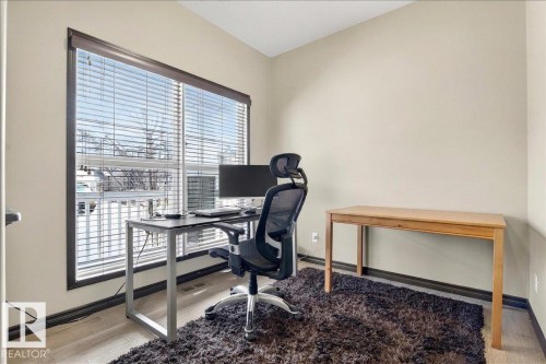 This room features a large window with blinds, light-toned walls, and wood flooring - 1530 Chapman Way, Edmonton, AB - Indoor Photo Showing Office