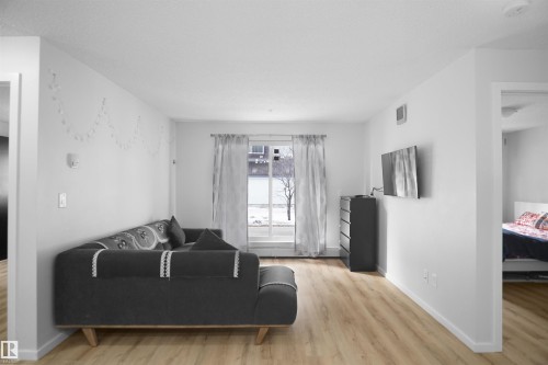 The property features light-colored flooring, white walls, and a window with sheer curtains - 103 3353 16A Avenue, Edmonton, AB - Indoor