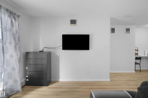 Living area featuring light-colored walls and light wood flooring - 103 3353 16A Avenue, Edmonton, AB - Indoor