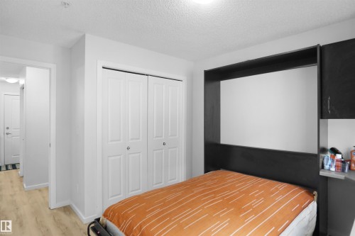 The property features light-toned flooring, white walls, and a closet with bi-fold doors - 103 3353 16A Avenue, Edmonton, AB - Indoor Photo Showing Bedroom