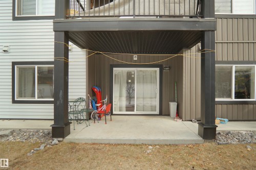 The property features a concrete patio area with an overhead balcony, offering an outdoor space - 103 3353 16A Avenue, Edmonton, AB - Outdoor With Deck Patio Veranda With Exterior