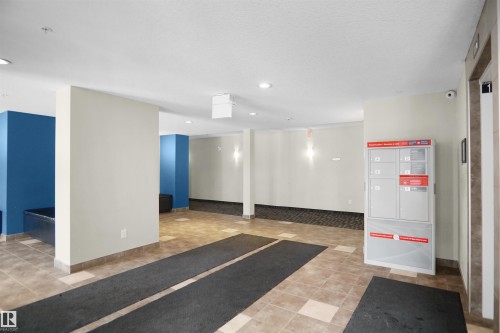 Building common area featuring tiled flooring, recessed lighting, and a modern mail delivery system - 103 3353 16A Avenue, Edmonton, AB - Indoor Photo Showing Other Room