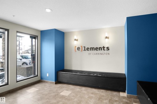 Welcoming lobby area featuring large windows, tiled flooring, and a built-in bench - 103 3353 16A Avenue, Edmonton, AB - Indoor Photo Showing Other Room