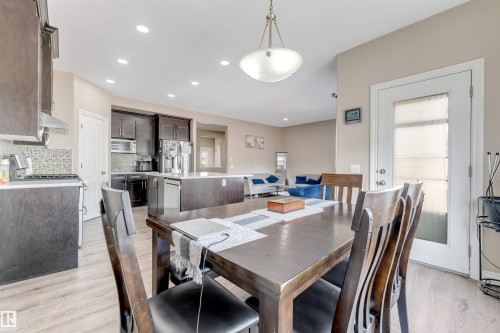 The property features an open-concept living space with a dining area, a kitchen with dark cabinetry, and a living room with light-colored walls - 121 64 Street, Edmonton, AB - Indoor Photo Showing Dining Room