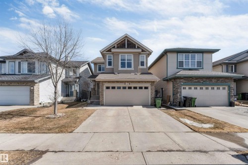 The property features a two-story design with a light-colored siding facade and stone accents - 121 64 Street, Edmonton, AB - Outdoor With Facade