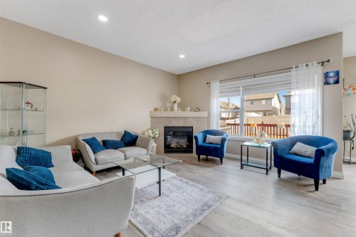 The living area features light-colored flooring and a fireplace with a light-toned mantel - 121 64 Street, Edmonton, AB - Indoor Photo Showing Living Room With Fireplace