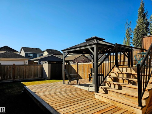 Spacious backyard featuring a large wooden deck with a gazebo, steps, and railing - 6888 Evans Wynd, Edmonton, AB - Outdoor With Exterior