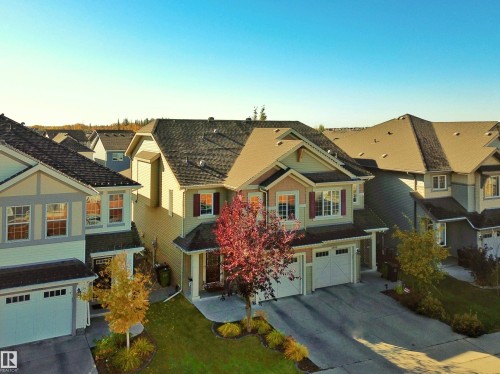 The property features a two-story design with a light-colored exterior and contrasting dark roof - 6888 Evans Wynd, Edmonton, AB - Outdoor With Facade