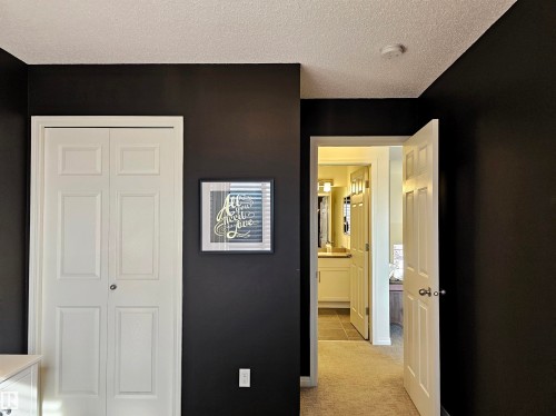 This space features dark walls and light-colored trim - 6888 Evans Wynd, Edmonton, AB - Indoor Photo Showing Other Room