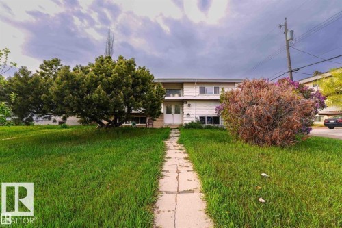 The property features a front yard with a concrete pathway leading to the main entrance, a large mature tree, and a shrub - 12708 133A Avenue, Edmonton, AB - Outdoor