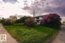 The property features a well-maintained lawn with mature trees and a prominent flowering shrub - 12708 133A Avenue, Edmonton, AB  - Outdoor 