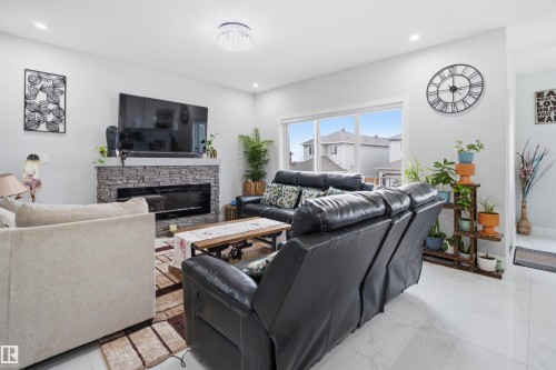 Living area featuring light-colored walls, recessed lighting, and a chandelier - 2420 13 Avenue, Edmonton, AB - Indoor Photo Showing Living Room With Fireplace