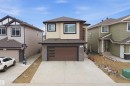 This property features a modern exterior with a mix of beige stucco and dark stone accents, complemented by a brown garage door with horizontal frosted glass inserts - 2420 13 Avenue, Edmonton, AB  - Outdoor 