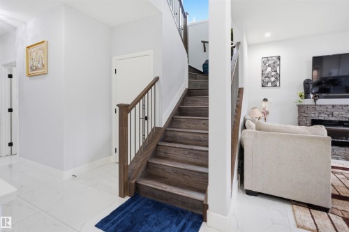 The property features a staircase with wooden treads and a railing with dark wood and metal balusters - 2420 13 Avenue, Edmonton, AB - Indoor Photo Showing Other Room