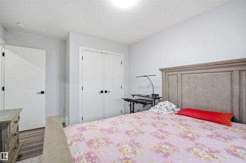 A bedroom featuring light-colored walls, recessed lighting, and a light wood-toned bed frame with a paneled headboard - 2420 13 Avenue, Edmonton, AB - Indoor Photo Showing Bedroom