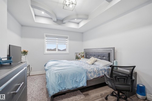 The room features a decorative tray ceiling with recessed lighting and a contemporary light fixture - 2420 13 Avenue, Edmonton, AB - Indoor Photo Showing Bedroom