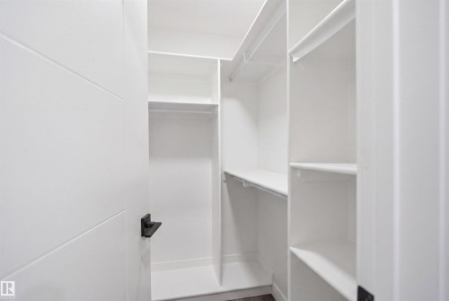 Well-appointed closet with white shelving and hanging rods - 2420 13 Avenue, Edmonton, AB - Indoor With Storage