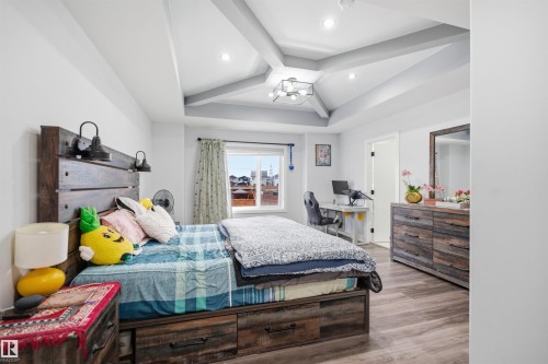 This room features a vaulted ceiling with recessed lighting and a contemporary light fixture - 2420 13 Avenue, Edmonton, AB - Indoor Photo Showing Bedroom