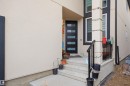 The property features a modern front entrance with a dark entry door and frosted glass panels - 2420 13 Avenue, Edmonton, AB  -  With Exterior 