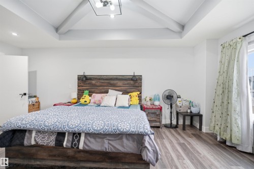 Bedroom featuring a vaulted ceiling with exposed beams, a ceiling light fixture, and hardwood floors - 2420 13 Avenue, Edmonton, AB - Indoor Photo Showing Bedroom