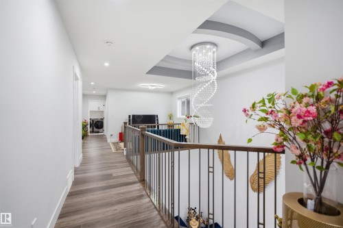 Upper landing featuring hardwood flooring, recessed lighting, and a decorative ceiling with an elegant chandelier - 2420 13 Avenue, Edmonton, AB - Indoor Photo Showing Other Room