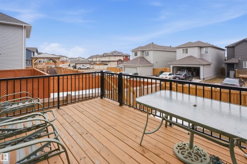 The property features a wooden deck with a black metal railing and a lattice privacy screen - 2420 13 Avenue, Edmonton, AB - Outdoor With Exterior