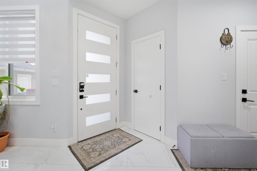 Entryway featuring a modern door with horizontal frosted glass panels, white tiled flooring, and light gray walls - 2420 13 Avenue, Edmonton, AB - Indoor Photo Showing Other Room