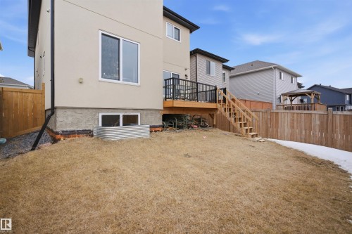 The property features a private backyard with a wooden fence, a wooden deck, and a wooden staircase - 2420 13 Avenue, Edmonton, AB - Outdoor With Exterior