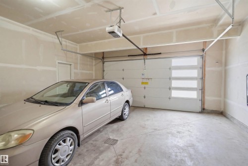 The property features a garage with a concrete floor, an overhead garage door with frosted glass panels, and an automatic garage door opener - 2420 13 Avenue, Edmonton, AB - Indoor Photo Showing Garage