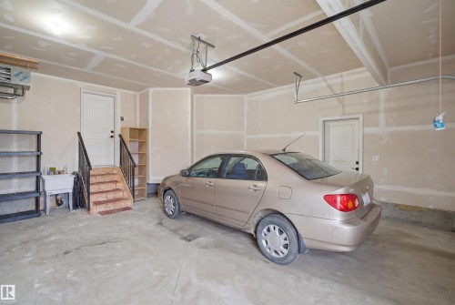 The garage features a concrete floor, a utility sink, and interior access via a set of stairs - 2420 13 Avenue, Edmonton, AB - Indoor Photo Showing Garage