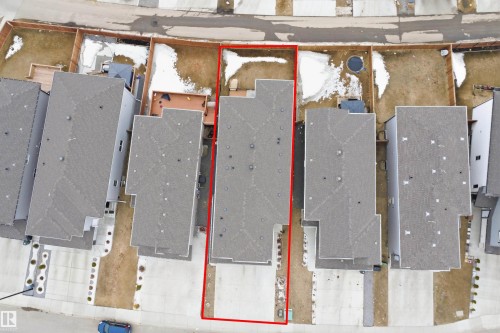 Aerial view of the property, outlined in red, featuring a grey roof and a driveway - 2420 13 Avenue, Edmonton, AB - 