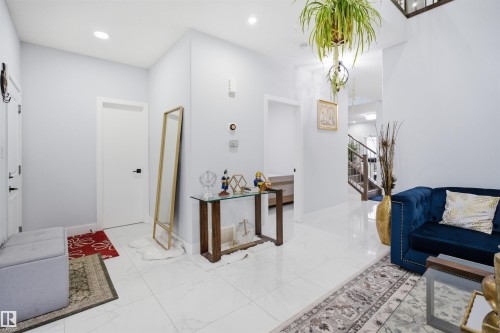 The property features light-colored walls and white tile flooring throughout this interior space - 2420 13 Avenue, Edmonton, AB - Indoor Photo Showing Other Room