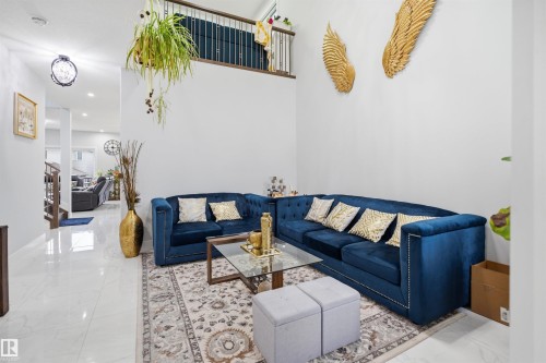 The spacious living area features high ceilings and white walls, creating an airy ambiance - 2420 13 Avenue, Edmonton, AB - Indoor Photo Showing Living Room