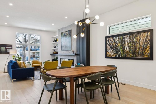 Open concept living and dining area featuring light-colored hardwood floors, recessed lighting, and a contemporary light fixture - 11146 62 Street Nw, Edmonton, AB - Indoor Photo Showing Dining Room