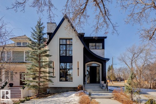 The property's distinctive exterior features a striking black and white facade with an arched entryway and large windows - 11146 62 Street Nw, Edmonton, AB - Outdoor With Facade