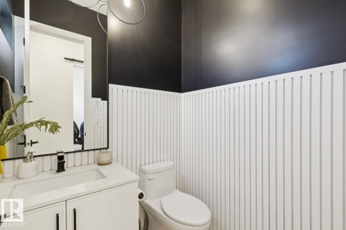 Bathroom featuring white wainscoting, a white vanity with a rectangular sink, and a toilet - 11146 62 Street Nw, Edmonton, AB - Indoor Photo Showing Bathroom