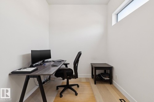 This versatile room features light hardwood flooring, white walls, and a high horizontal window providing natural light - 11146 62 Street Nw, Edmonton, AB - Indoor Photo Showing Office