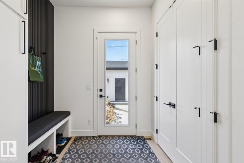 Entryway with a built-in bench, storage cubbies, and a textured accent wall - 11146 62 Street Nw, Edmonton, AB - Indoor Photo Showing Other Room