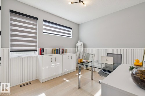 This versatile room features light-colored flooring, windows with horizontal blinds, and a light-colored wall with wainscoting - 11146 62 Street Nw, Edmonton, AB - Indoor