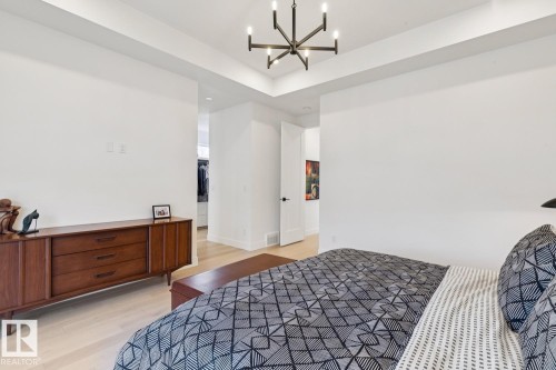 This living space features light-colored flooring and a modern ceiling fixture - 11146 62 Street Nw, Edmonton, AB - Indoor Photo Showing Bedroom