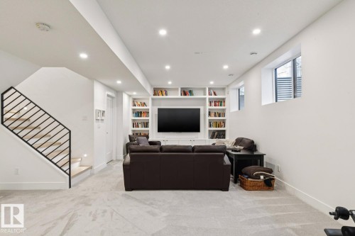 The living area features built-in shelving, recessed lighting, and windows providing natural light - 11146 62 Street Nw, Edmonton, AB - Indoor